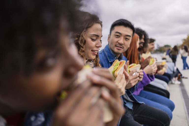 multiethnic-friends-placed-in-line-having-snack-f-2024-01-24-13-44-34-utc.jpg